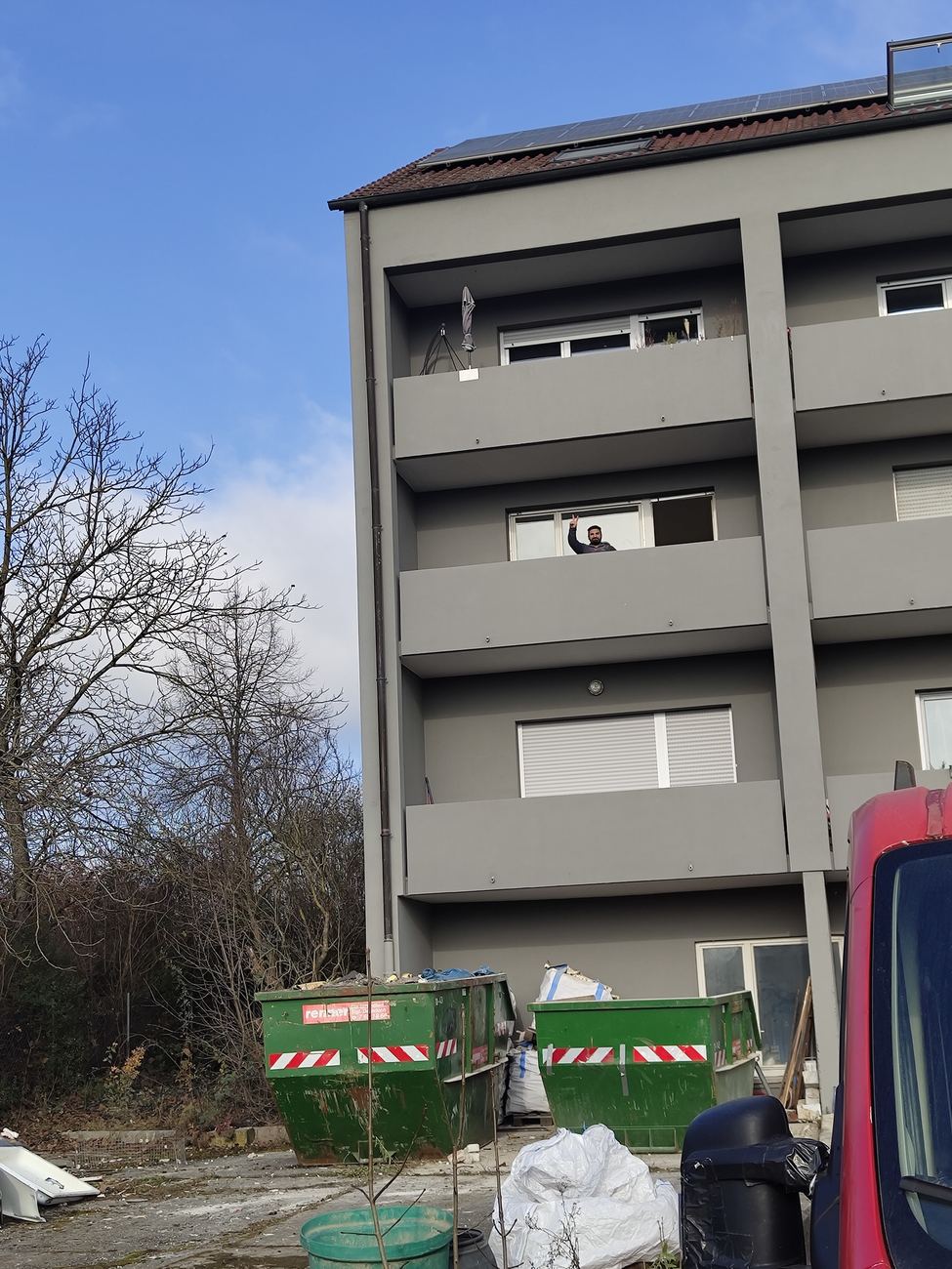 SOMO-Mitarbeiter grüßt vom Balkon einer Baustelle in Stuttgart